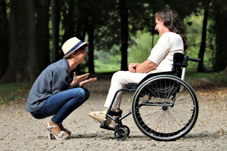 Two women enjoy a lively conversation in a sunny park, embracing friendship and happiness.